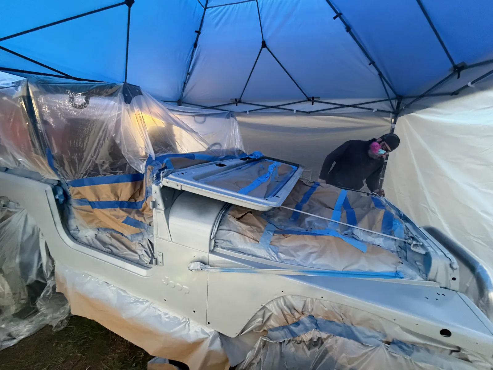 The Jeep in grey primer under the canopy at night