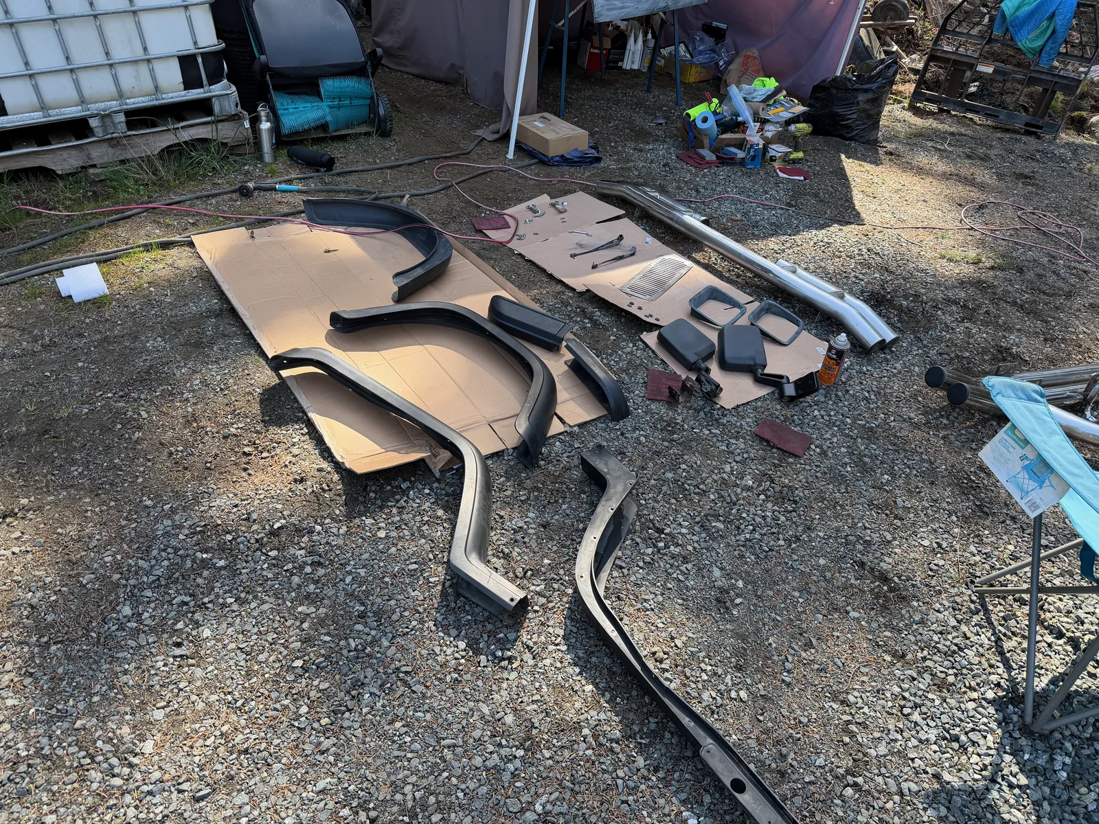 Freshly painted body panels and parts laid out on the ground