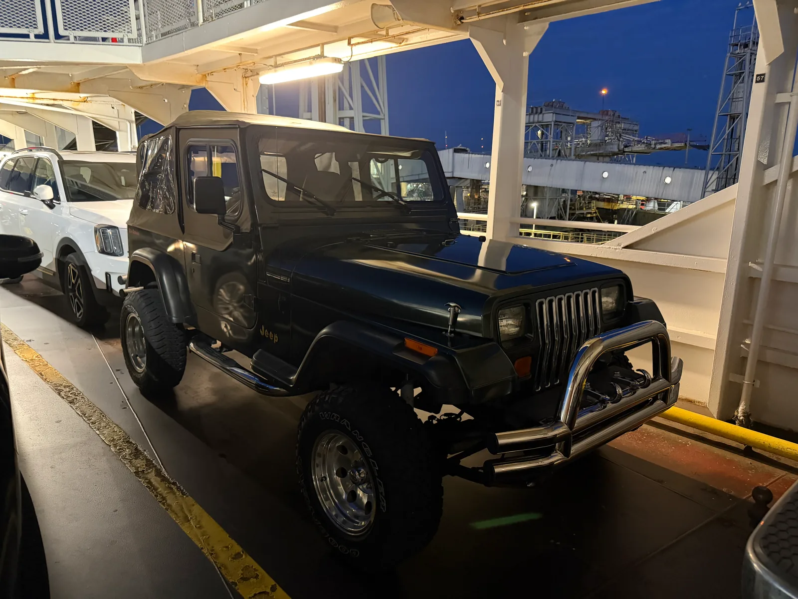The metallic green Jeep Wrangler YJ parked on the car deck of a BC ferry