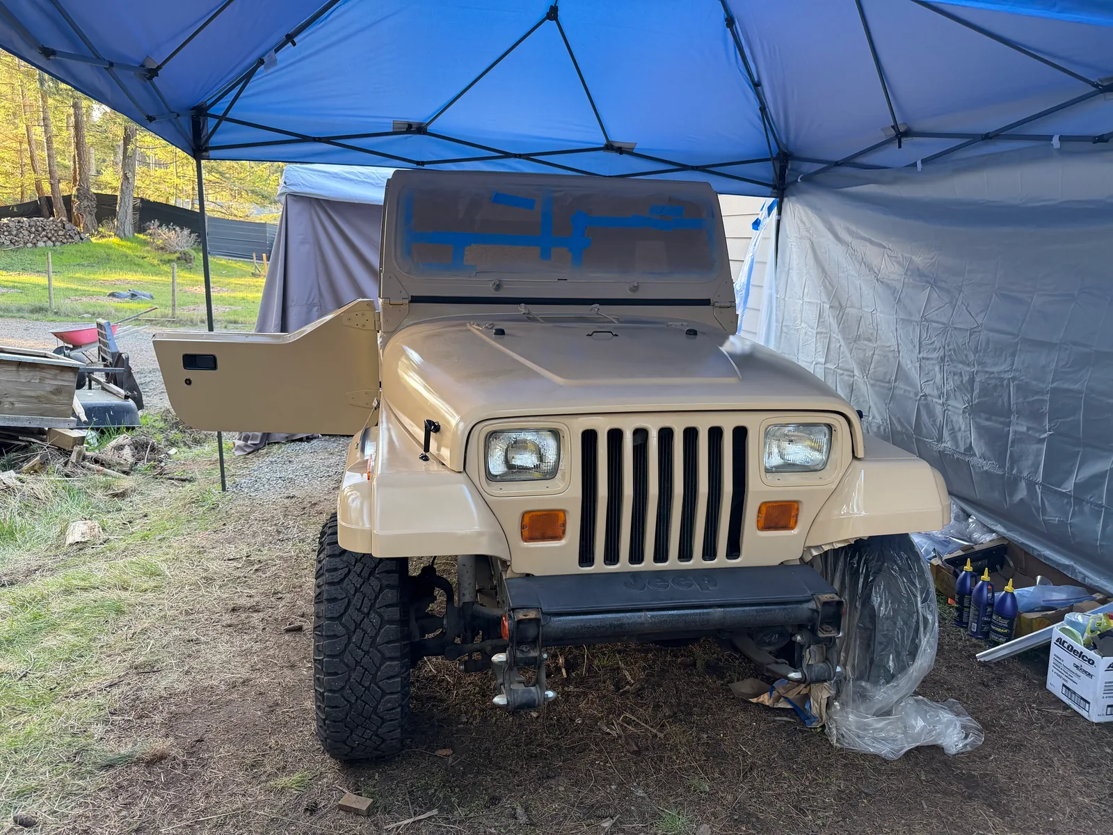 The front grille of the tan Jeep masked and waiting for red accents