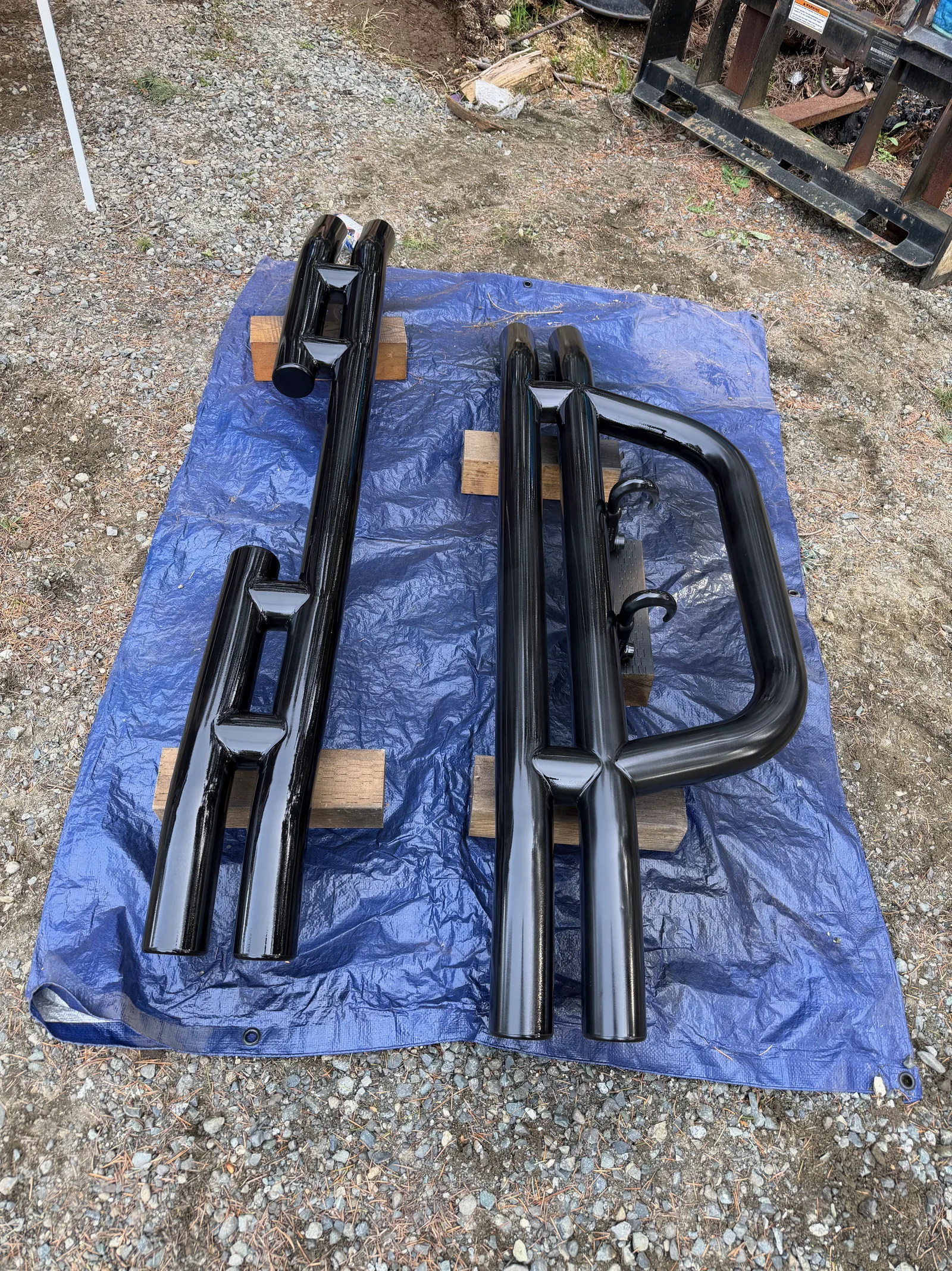 Roll bars and parts laid out on a tarp for measuring and masking