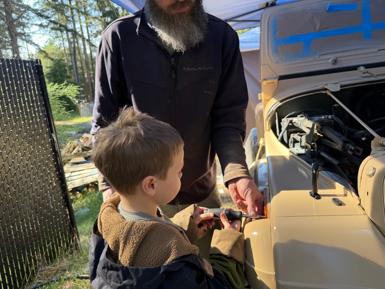 Grandpa and our son working together on the finished Jeep