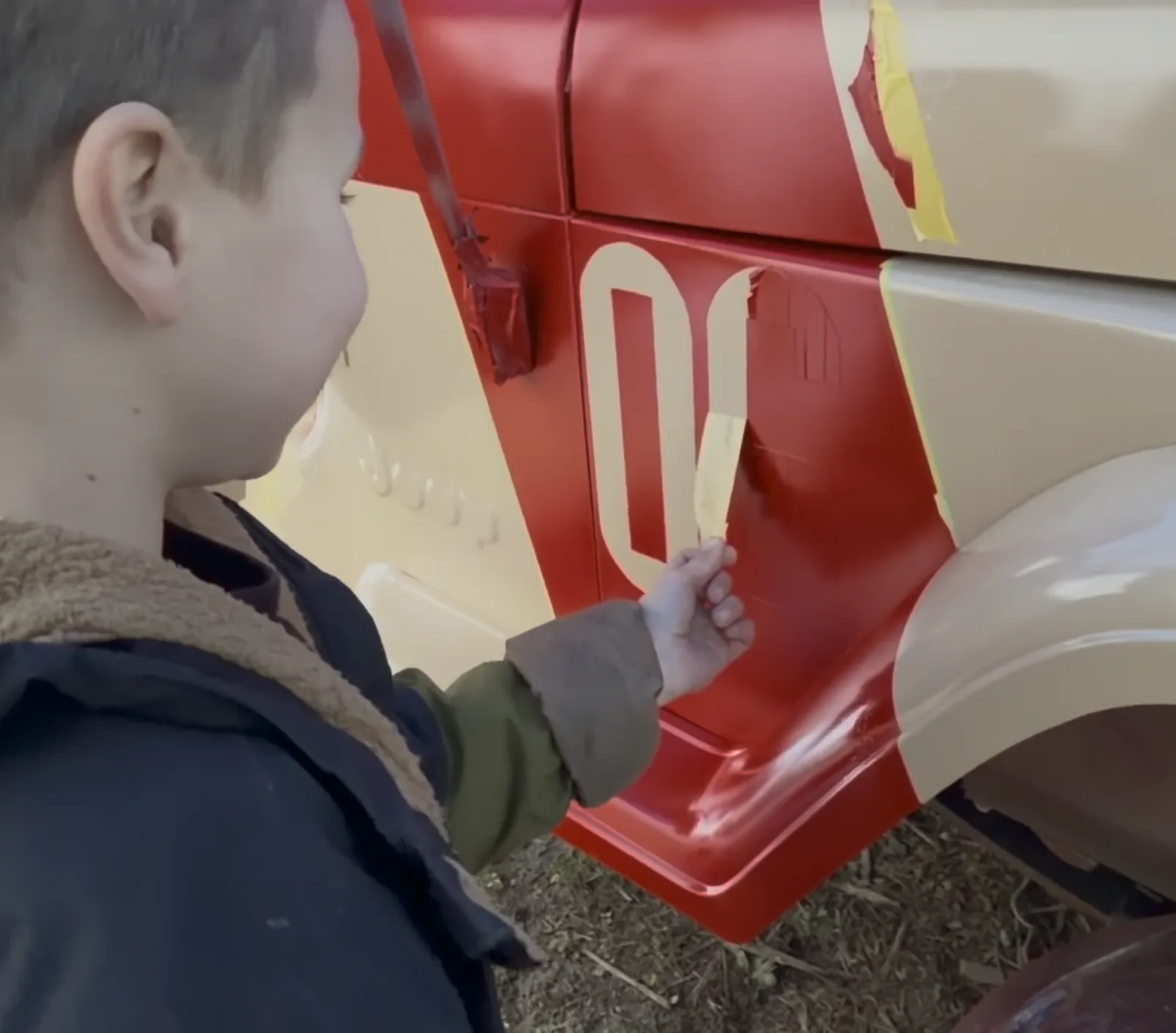 Our son next to the red-accented body panel with the number 06