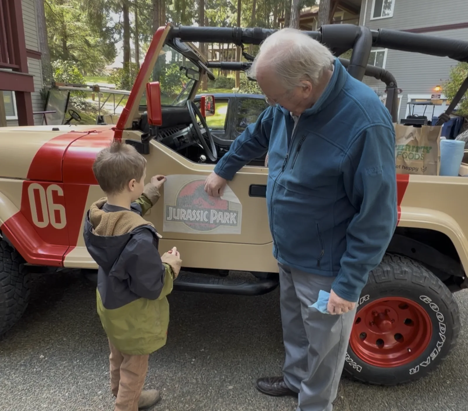 Grandpa and our son standing beside the finished Jurassic Park Jeep