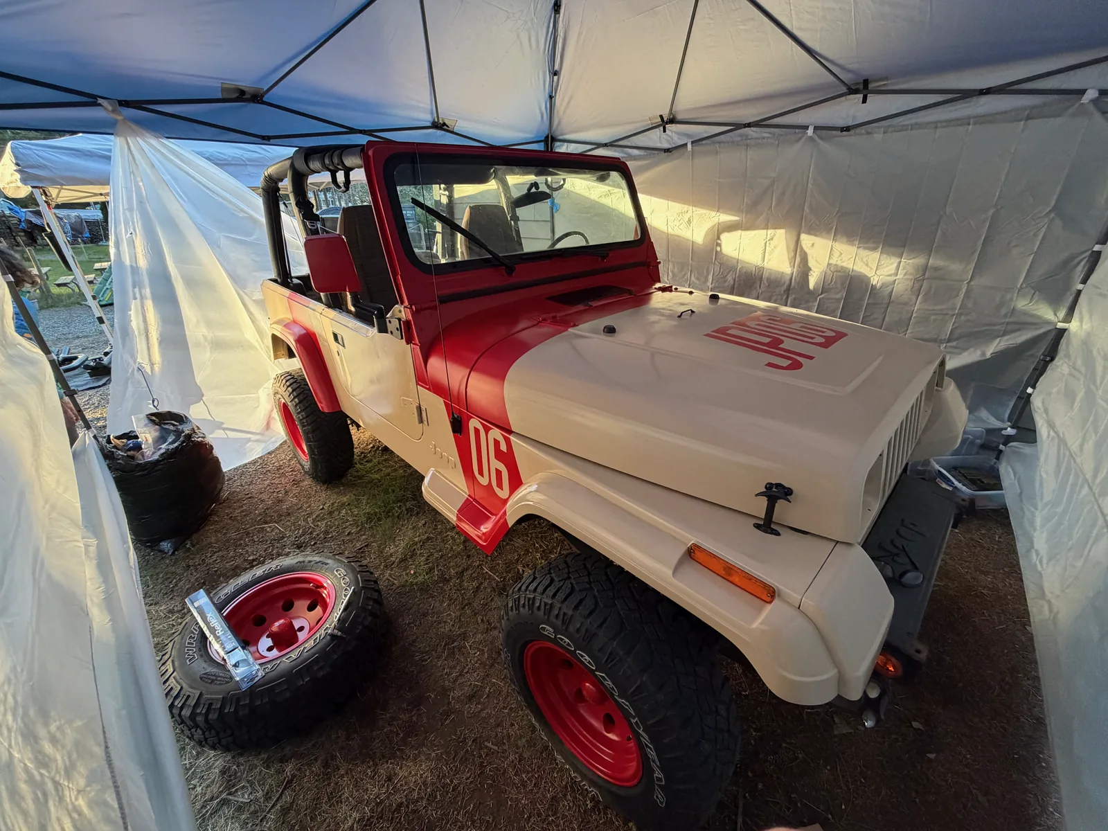 The finished tan and red Jurassic Park Jeep under the canopy
