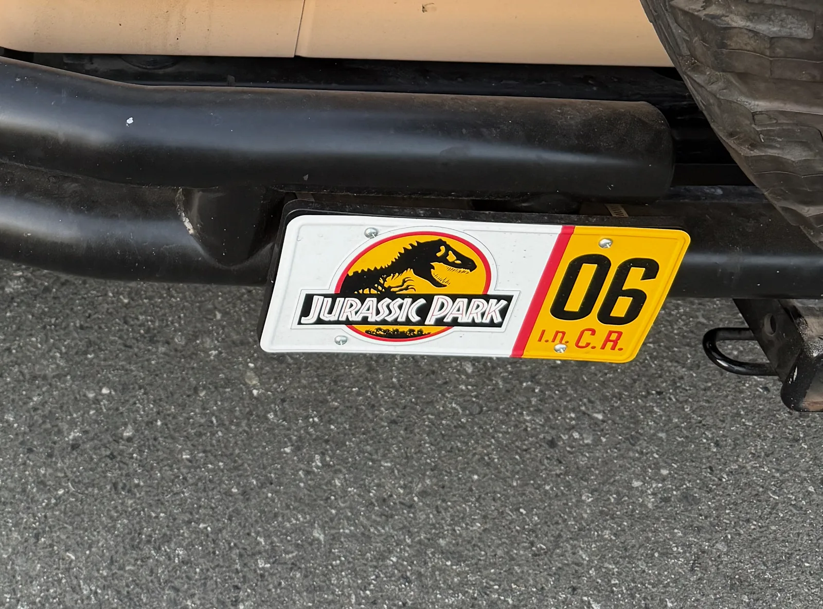 The Jurassic Park '06' novelty license plate mounted on the Jeep
