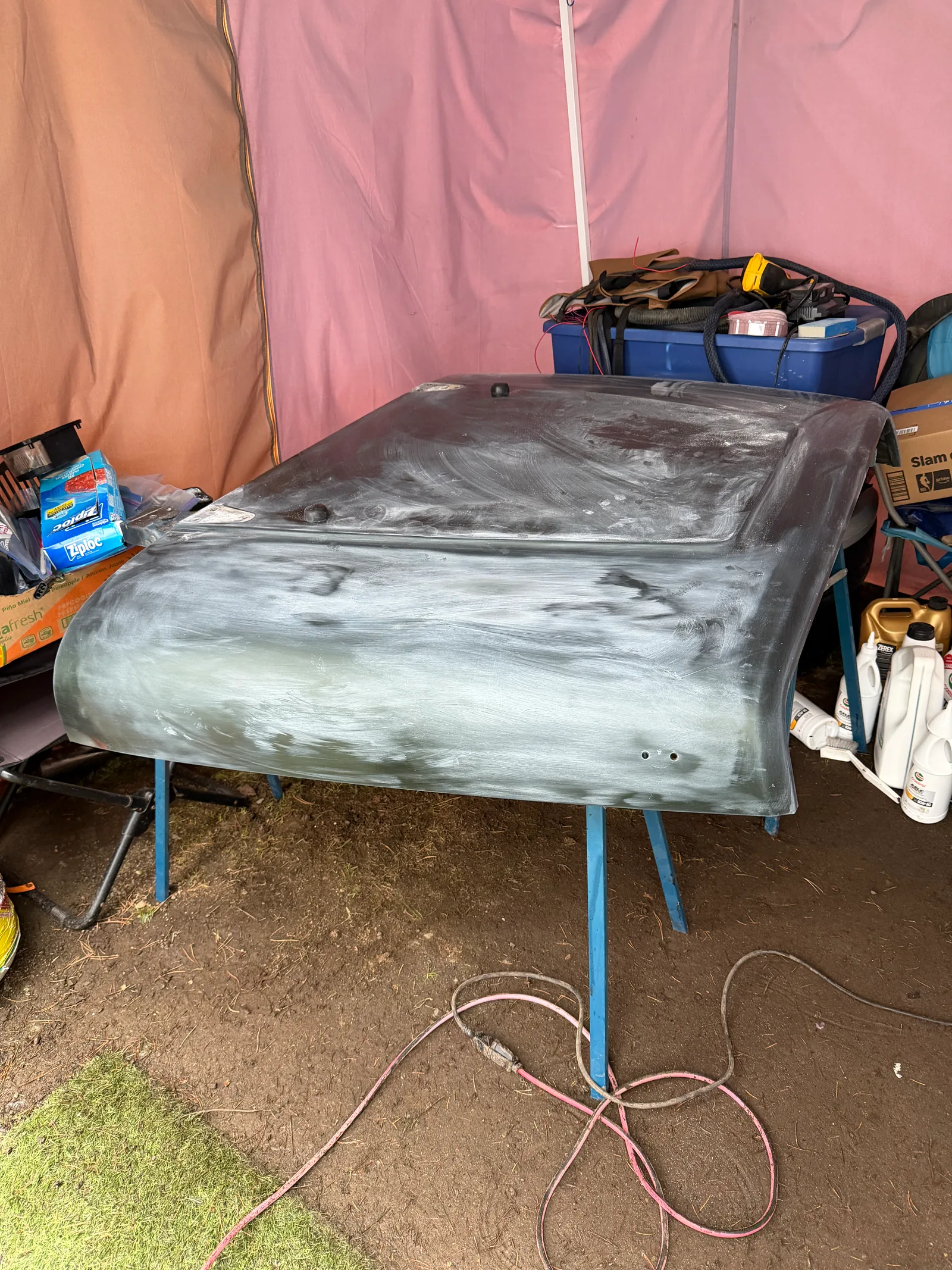 A Jeep body panel up on stands being prepped