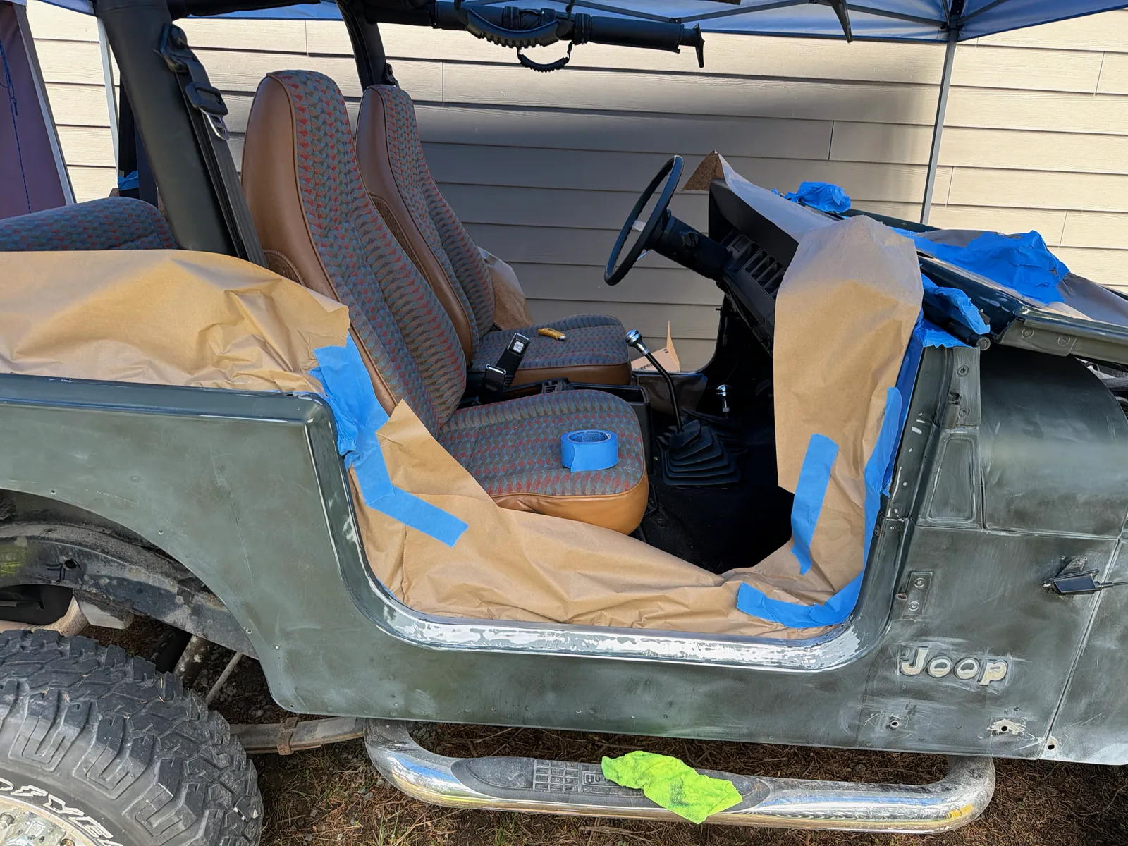 The Jeep interior and seats masked off with tape and paper