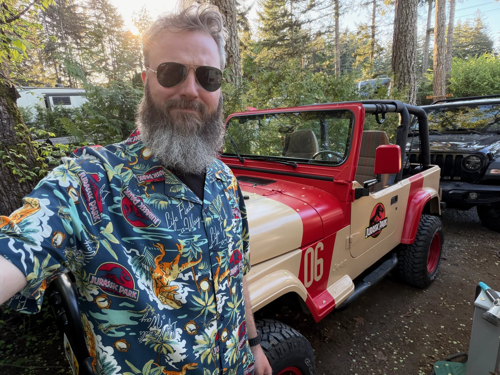 Craig in a tropical shirt standing beside the finished Jurassic Park Jeep